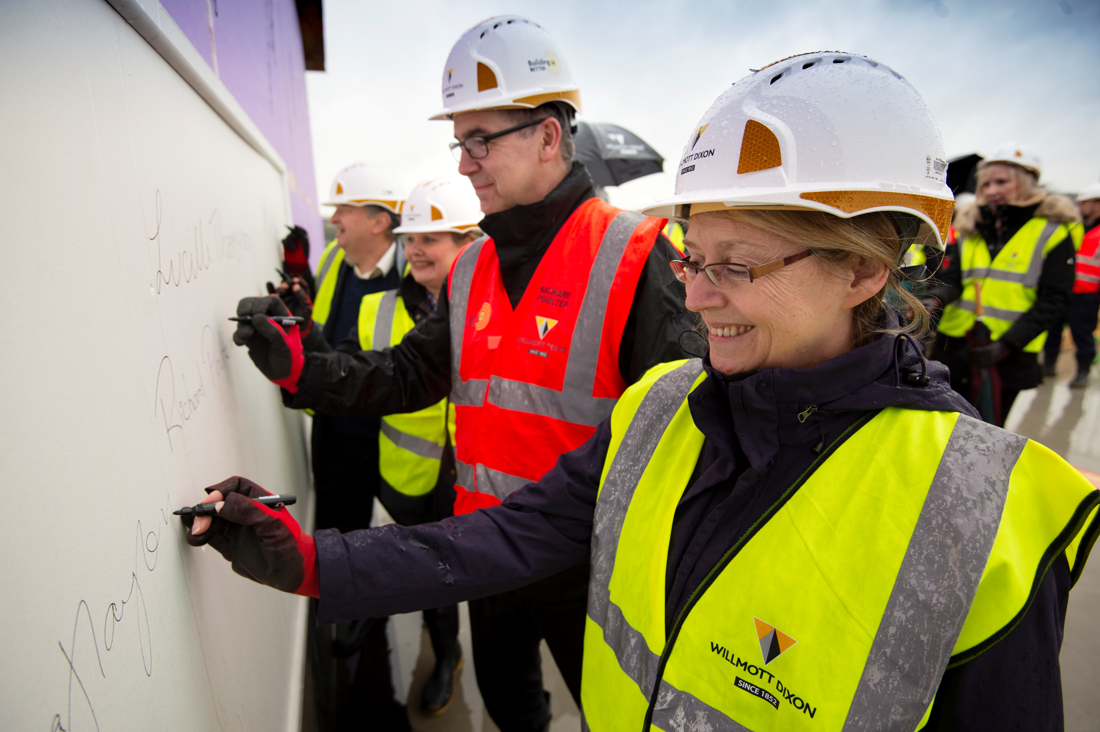 Cllr Prince, Leader of the council Cllr Thompson, Richard Poulter at Willmott Dixon and council Chief Executive Laura Taylor signing the building